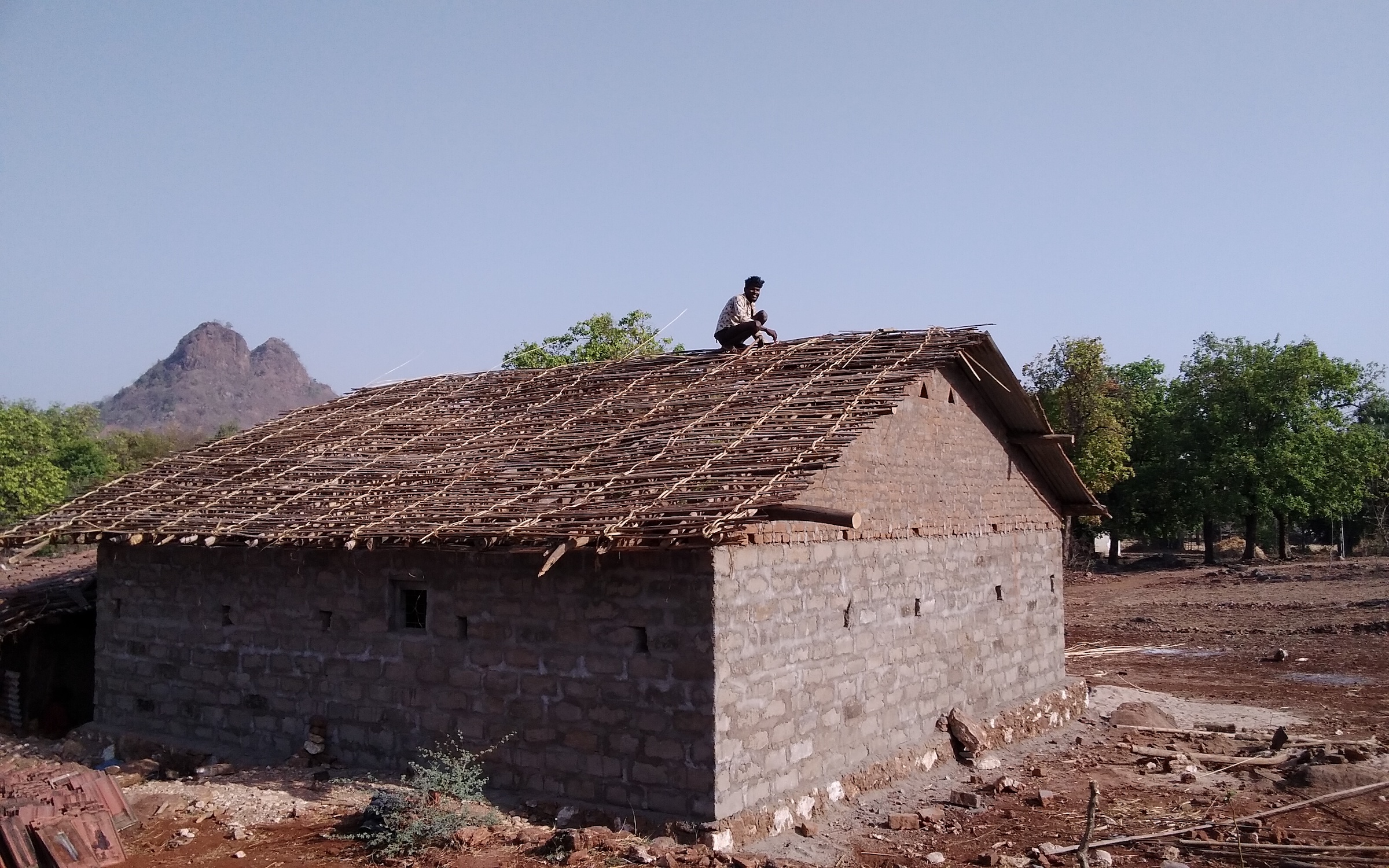 Rathwa man doing house repairs, Moti Sadli, Gujarat.